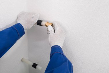 Eller çapraz bağlı polietilen boru bileşenleri kurulumunu gerçekleştirir