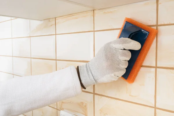 Mãos Mestre Esfregando Uma Argamassa Marrom Uniões Azulejos Brancos Com — Fotografia de Stock