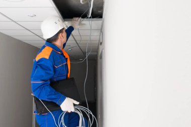 Bir işçi, evlerde ve ofislerde internet kurulumu için teknik işler yapar.