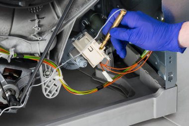 Çamaşır makinesinin elektrik kontrol ekipmanlarını test ediciyle yakın çekim arızası nedeniyle kontrol ediyorum.