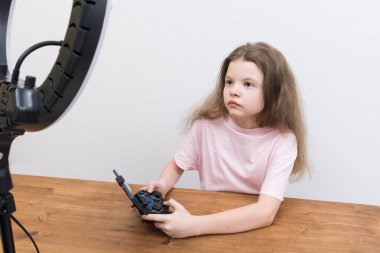 Oyuncu kız, oyunda bir joystick ile oynuyor telefonda, dairesel bir ışıkla.