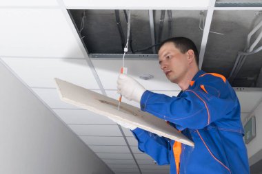 Usta lambayı asma tavandaki gizli elektrik kablolarına bağlıyor, yakın plan.