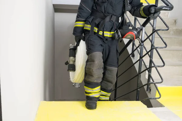 Egy Tűzoltó Mászik Fel Lépcsőn Hord Magánál Egy Tömlővezetéket Tűzoltó — Stock Fotó