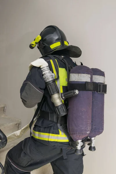 Brandweerman Speciale Kleding Houdt Een Mouw Lijn Achteraanzicht — Stockfoto
