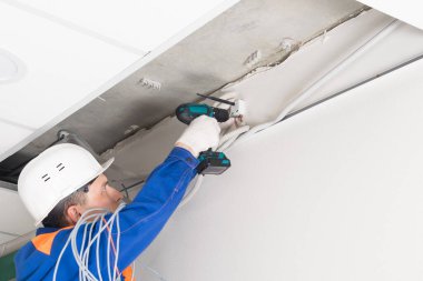 İşçi, evlere ve ofislere internet sinyali göndermek için duvara yönlendirici yerleştirir