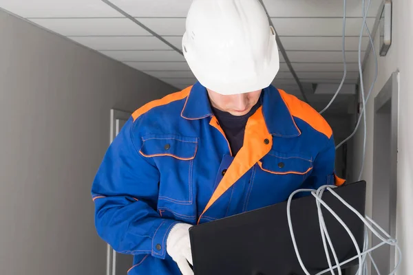 a worker configures a secure Internet in a building using a laptop, close-up