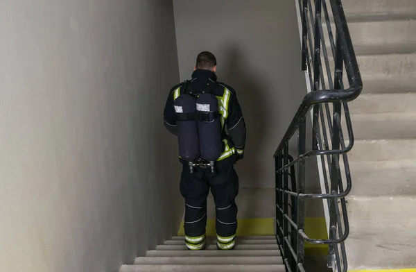 消防员带着呼吸器下楼梯 — 图库照片