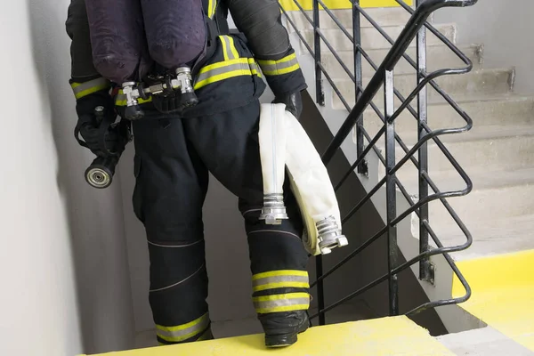 Strażak Przewozi Węża Sprzęt Gaszenia Pożarów Pomieszczeniach — Zdjęcie stockowe
