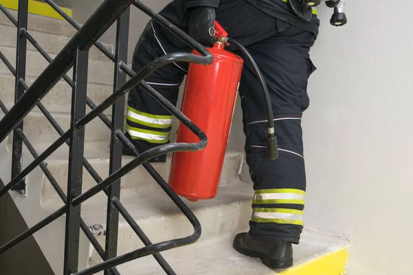 Ein Feuerwehrmann Steigt Die Treppe Hinauf Und Trägt Einen Roten — Stockfoto