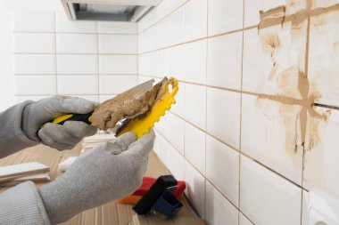 Efendinin elleri spatulaya kahverengi harç sürüp dairedeki işi bitiriyor.