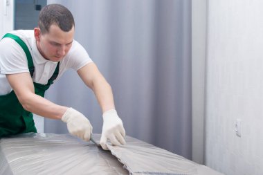 Kartonu nemden korumak için yoğun polietilen kesiyor.