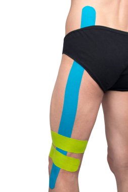 Bir adamın kalçasında, Kinesio bantları yapıştırılır, bir yaralanmadan sonra ve hızlı bir iyileşme için