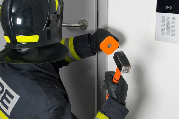 Close Firefighter Protective Clothing Hard Hat Trying Open Door Sledgehammer —  Fotos de Stock