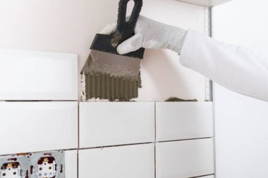 Beyaz kiremitleri duvara sürme işlemi, çözeltiye bir demir spatula uygulanır