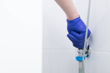 Çamaşır makinesinin su ve kanalizasyonuna bağlı. Koruyucu bir eldiven verin.