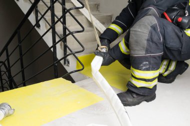 İtfaiyeci su kaynaklarını yangın bölgesine bağlıyor.