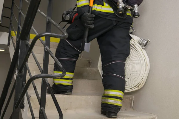 消防士はドアを開閉する装置で階段を登り — ストック写真