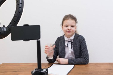 Kız blogcu, bir video yayını sırasında, su içiyor.