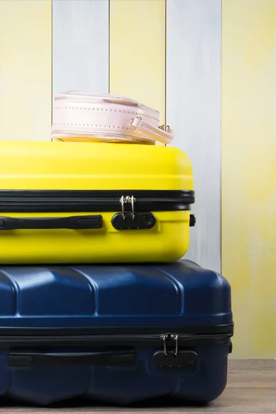 packed suitcases for travel, lying on top of each other, on a yellow-gray background