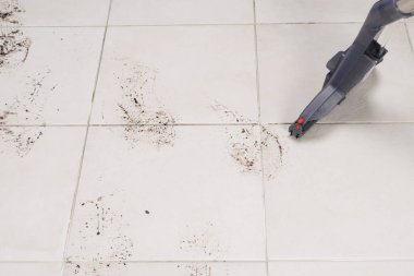 Kirli lekeli hafif fayanslar, elektrikli süpürgeyle temizlik.