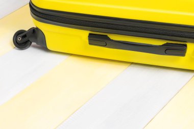 Sarı arka planda seyahat için bir bavul ve yazıtlar için bir yer.