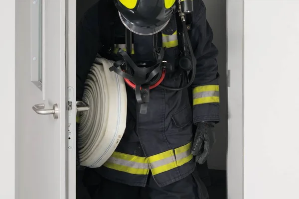 Brandweerman Met Uitrusting Gaat Door Een Open Ijzeren Deur — Stockfoto