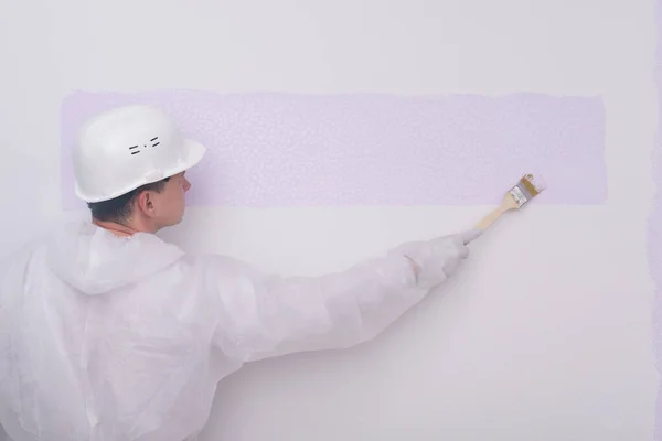 Pintor Ropa Protectora Casco Pinta Una Pared Blanca Color Púrpura —  Fotos de Stock