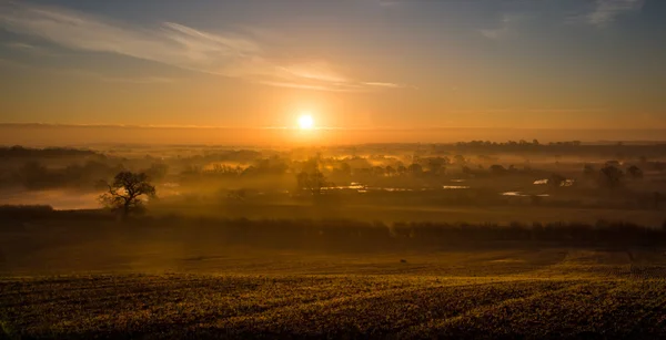 Sonnenstrahlen breiten sich über kilometerlange neblige Landschaft aus — Stockfoto