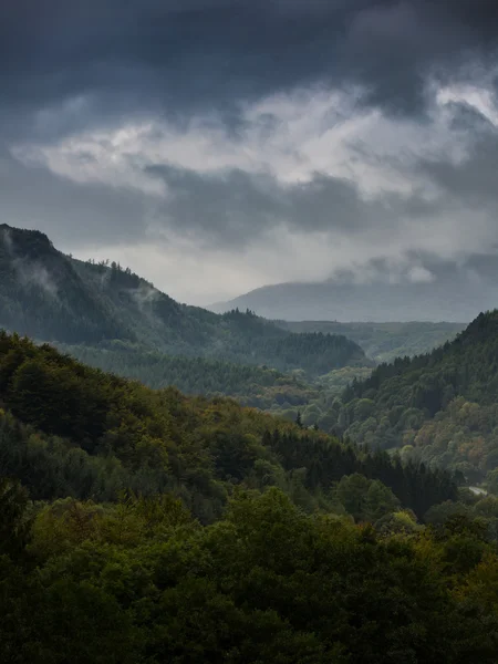 Storm clearing, the end of storm clouds moving over the forests and mountains — Stock Photo, Image