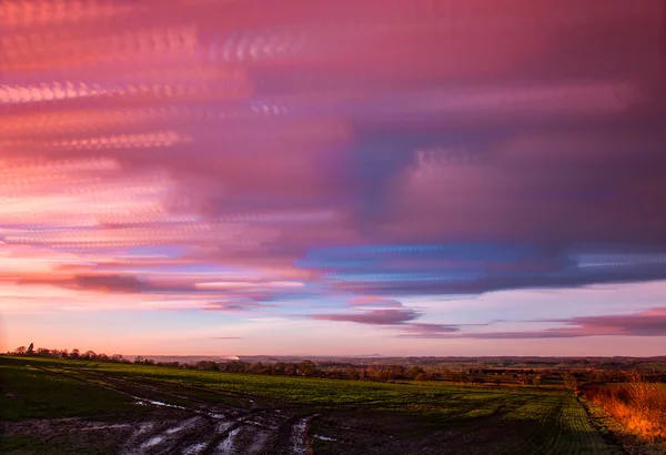 Timelapse movement of clouds at sunset with  far reaching scenic landscape — Stock Photo, Image