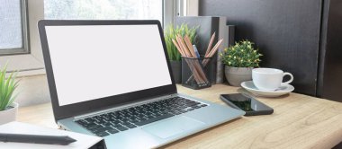 Çalışma masasında beyaz boş ekranlı dizüstü bilgisayar ve uzay konseptini kopyala