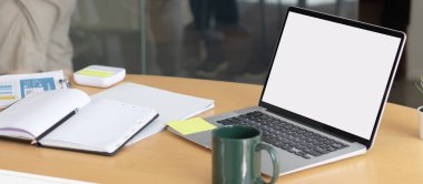 Çalışma masasında beyaz boş ekranlı dizüstü bilgisayar ve uzay konseptini kopyala