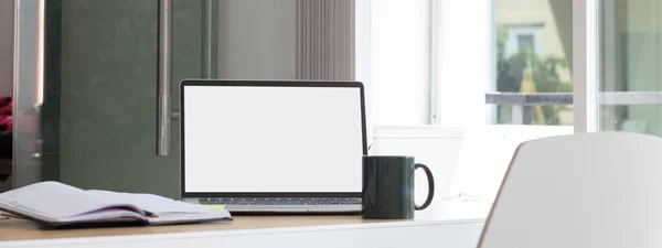 Laptop computer with white blank screen on desk in workspace and copy space concept