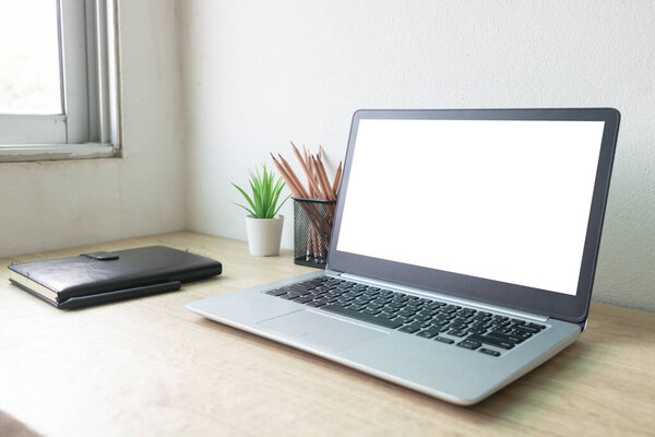 Laptop computer with white blank screen on wood desk. Workspace, workplace, desktop office concept.