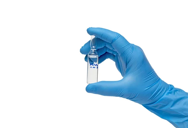 Seringa de mão enluvada médica com uma pérola de líquido emergente testando a função da seringa — Fotografia de Stock