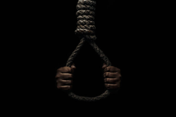 Hand holds a noose on a black background. Social problem. The end of the path