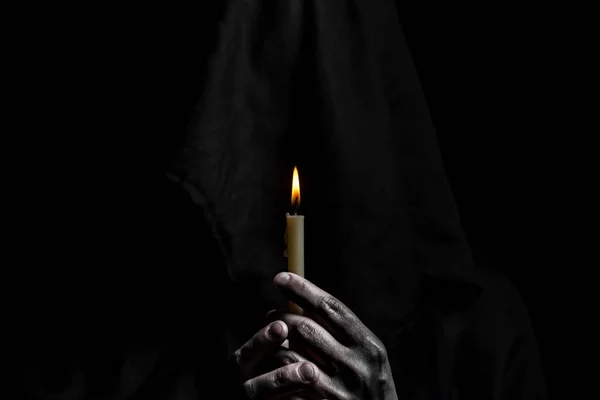 年轻的天主教修女手里拿着蜡烛 专注于蜡烛 脸很模糊 照片为黑色背景 — 图库照片