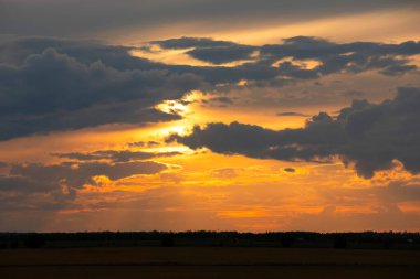 Güzel parlak turuncu ve koyu mavi gün batımı bozkırlarda. Karanlık çöktükten sonra ılık sonbahar huzurlu atmosferinde tarım arazisi.