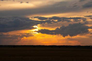 Güzel parlak turuncu ve koyu mavi gün batımı bozkırlarda. Karanlık çöktükten sonra ılık sonbahar huzurlu atmosferinde tarım arazisi.