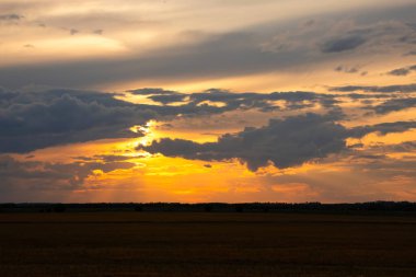 Güzel parlak turuncu ve koyu mavi gün batımı bozkırlarda. Karanlık çöktükten sonra ılık sonbahar huzurlu atmosferinde tarım arazisi.