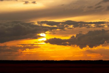 Güzel parlak turuncu ve koyu mavi gün batımı bozkırlarda. Karanlık çöktükten sonra ılık sonbahar huzurlu atmosferinde tarım arazisi.