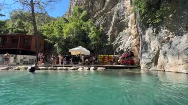 Kemer, Türkiye - 24 Eylül 2025: Turistler doğal bir yüzme sahasında boş zaman aktivitelerine girişiyor, canlı manzarayı ve ambiyansı yakalamak için kameralar çalışıyor