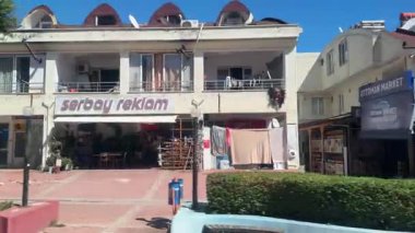 Kemer, Türkiye - 24 Eylül 2025: Sahil kenti sokak sahnesi mağazalar ve pazarlar, kamera tavaları canlı yerel işletmeleri ve atmosferi ortaya çıkarıyor