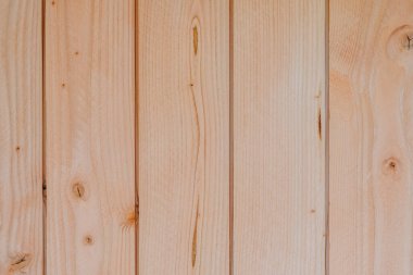 Close-up of light natural wooden planks with visible grain and knots. Clean, vertical wood panel texture ideal for backgrounds, decor, or architectural use.