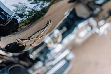 Valmiera, Letonya - 20 Haziran 2025: Motosiklet ambleminin çevreyi yansıtan yakın görüntüsü, krom kaplama ve parlak tasarım özellikleri