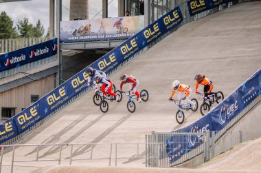 Valmiera, Letonya - 12 Temmuz 2025: BMX Avrupa Şampiyonası. BMX sürücüleri renkli pankartlar ve enerjik bir atmosferle pistte yarışıyorlar.