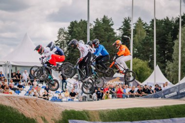 Valmiera, Letonya - 12 Temmuz 2025: BMX Avrupa Şampiyonası. Bir grup BMX sürücüsü heyecan verici bir yarışmada havada süzülüyor.