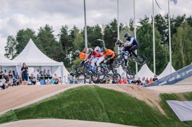 Valmiera, Letonya - 12 Temmuz 2025: BMX yarışçıları coşkulu izleyicilerin izlediği bir açık hava yarışmasında havada atlayışlar yapıyorlar. BMX Avrupa Şampiyonası