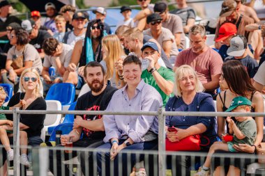 Valmiera, Letonya - 12 Temmuz 2025: Çeşitli izleyicilerden oluşan bir grup, parlak güneş altında heyecan ve canlı bir atmosfer içeren bir açık hava etkinliğinin tadını çıkarıyor. BMX Avrupa Şampiyonası