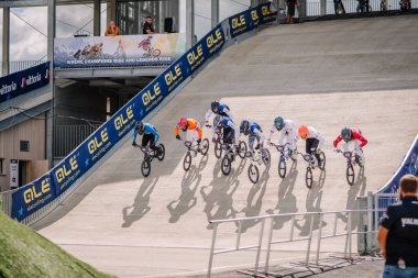 Valmiera, Letonya - 12 Temmuz 2025: BMX Avrupa Şampiyonası. Renkli pankartlar ve kalabalıkla BMX motosikletleriyle yarışan bisikletçiler